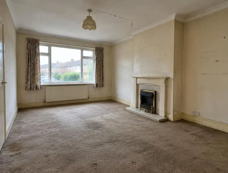 Living room before redecoration with stained walls and a cracked ceiling